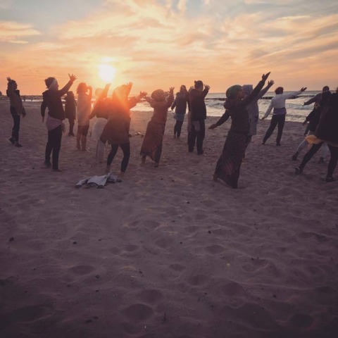 Grupa ludzi ćwiczących jogę na plaży w Niechorzu