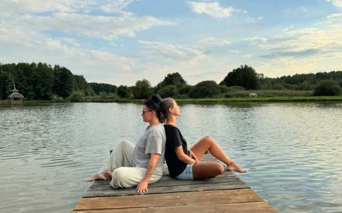 Weekend jogą w Ojrzanowie, kobiety na pomoście nad stawem