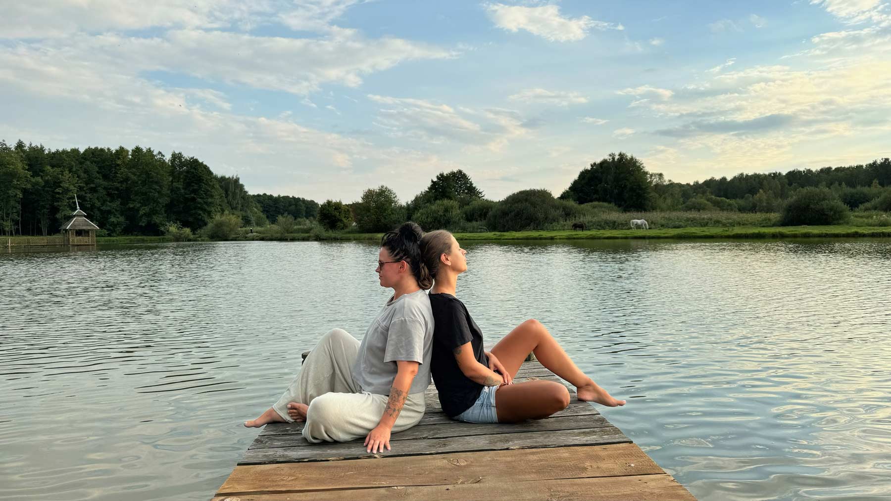 Weekend jogą w Ojrzanowie, kobiety na pomoście nad stawem